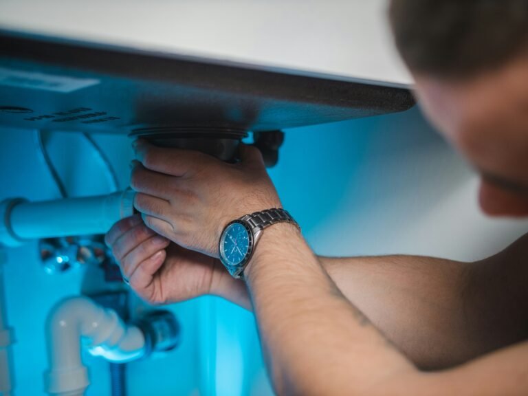 Technician removing an anode rod from the top of a storage water heater